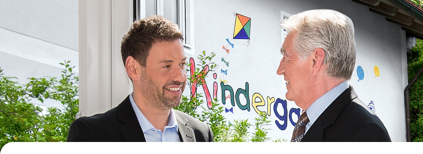 Beratung eines kommunalen Entscheidungsträgers zu Investkredit der BayernLabo vor Kindergarten.